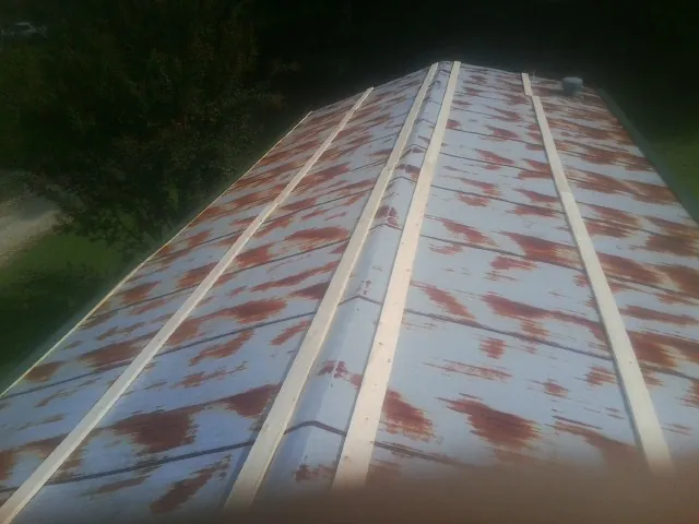 Rusted metal roof panels with new wood purlins before replacement — Storm Damage Roof Repair in Emery by Roofing Brothers