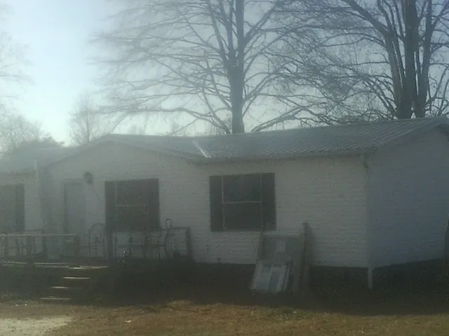 New metal roof on a white painted brick home on a foggy morning in Emery