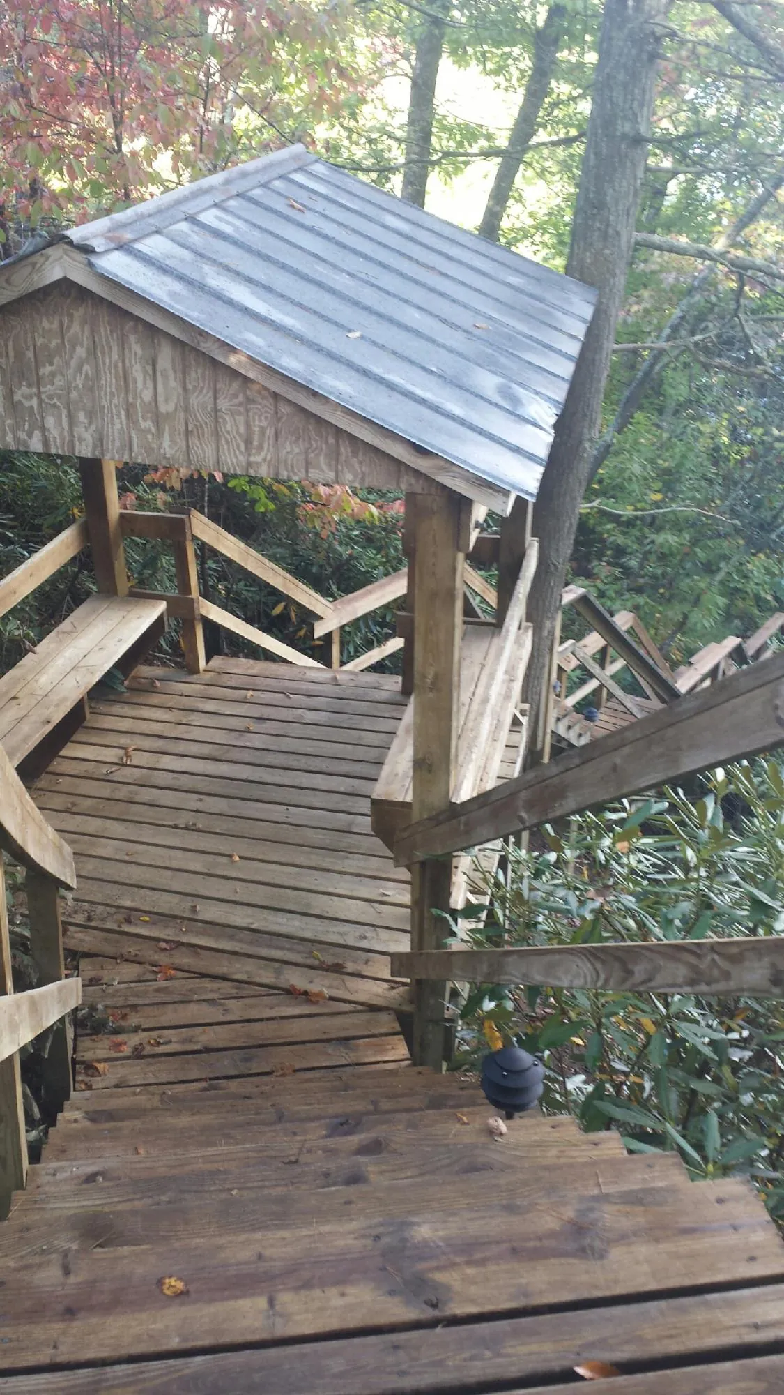 Metal roofed shelter over wooden steps on a wooded walkway — Skylight Repair & Installation work by our crew in Emery